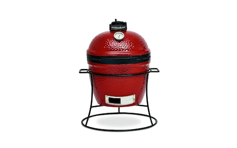 Kamado Joe red charcoal BBQ on a black stand with a temperature gauge 